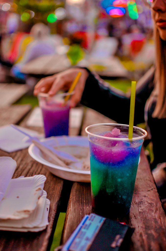 a woman sitting at a table with a drink in front of her